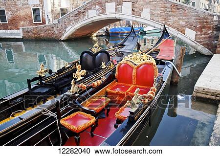 Stock Image - Gondolas in a canal; Venice, Italy. Fotosearch