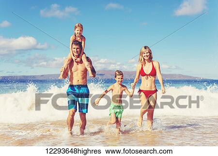 Stock Photograph - Happy family having fun on beautiful warm sunny beach.. Fotosearch