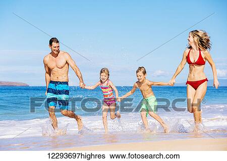 Stock Photograph - Happy family having fun on beautiful warm sunny beach.. Fotosearch