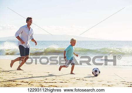 Happy Father and Son Having Fun Playing Soccer on the Beach View Large Photo Image Stock Photograph - Happy Father and Son Having Fun Playing Soccer on the Beach. Fotosearch