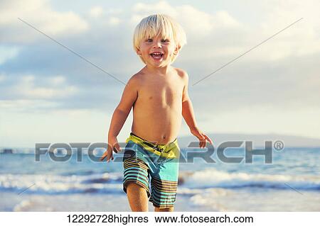 Happy young boy playing at the beach View Large Photo Image Stock Photograph - Happy young boy playing at the beach. Fotosearch