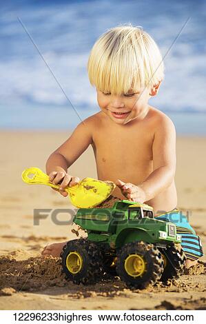 Happy young boy playing with toys at the beach View Large Photo Image Stock Photograph - Happy young boy playing with toys at the beach. Fotosearch