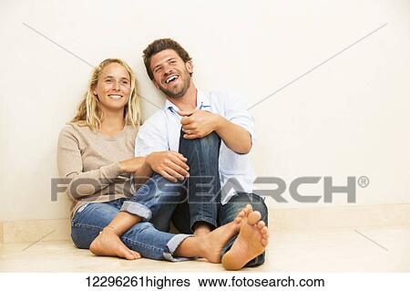Happy young couple at home relaxing on the floor View Large Photo Image Stock Photograph - Happy young couple at home relaxing on the floor. Fotosearch
