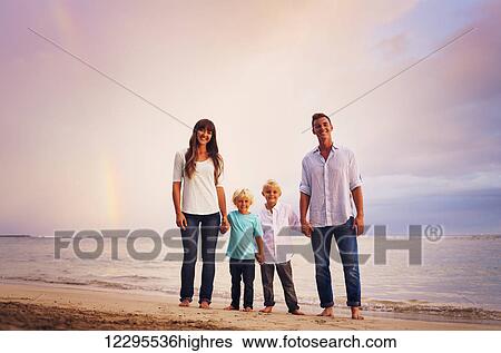 Happy young family on the beach at sunset with amazing rainbow View Large Photo Image Stock Photograph - Happy young family on the beach at sunset with amazing rainbow. Fotosearch