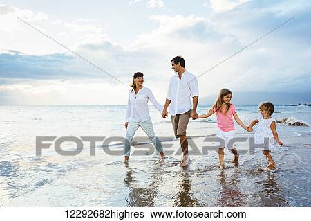 Happy young family walking on the beach at sunset. Happy Family Lifestyle View Large Photo Image Stock Photograph - Happy young family walking on the beach at sunset. Happy Family Lifestyle. Fotosearch