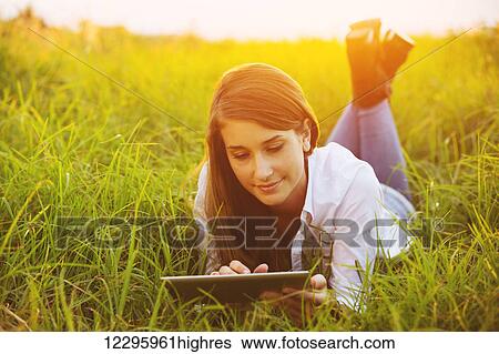 Stock Photograph - Happy Young Woman Using Tablet Outdoors. Fotosearch