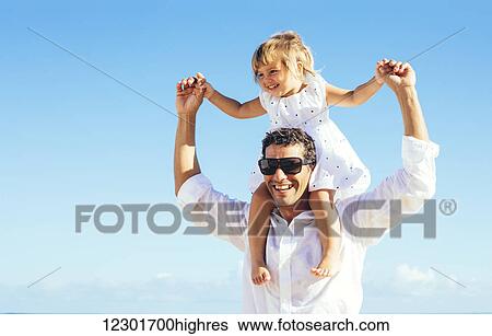 Stock Photograph - Healthy father and daughter playing together at the beach. Fotosearch