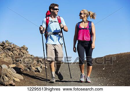 Hiking in the mountains. Athletic couple with backpacks enjoying hike outdoors. View Large Photo Image Stock Photograph - Hiking in the mountains. Athletic couple with backpacks enjoying hike outdoors.. Fotosearch