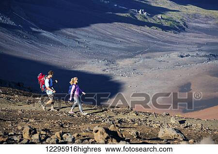Stock Photograph - Hiking in the mountains. Athletic couple with backpacks enjoying hike outdoors.. Fotosearch