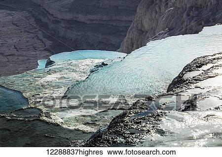 Stock Photograph - Hot springs and travertines, terraces of carbonate minerals left by the flowing water; Pamukkale, Turkey. Fotosearch