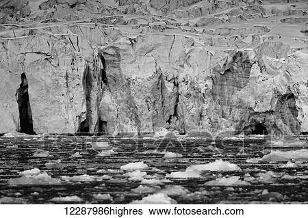 Stock Photograph - Ice cliff and pieces of ice floating, in the Arctic Ocean; Spitsbergen, Svalbard, Norway. Fotosearch
