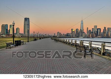 Stock Photograph - Jersey City and Manhattan skylines at sunset, Liberty State Park; Jersey City, New Jersey, United States of America. Fotosearch