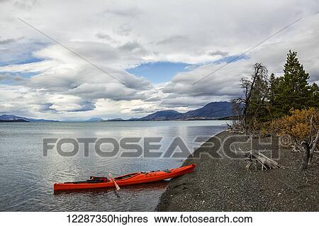 Kayak on the shore of Atlin Lake; British Columbia, Canada View Large Photo Image Stock Photograph - Kayak on the shore of Atlin Lake; British Columbia, Canada. Fotosearch