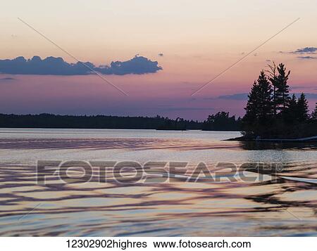 Lake of the Woods at sunrise with the pink sky reflected in the tranquil water; Ontario, Canada View Large Photo Image Stock Photograph - Lake of the Woods at sunrise with the pink sky reflected in the tranquil water; Ontario, Canada. Fotosearch