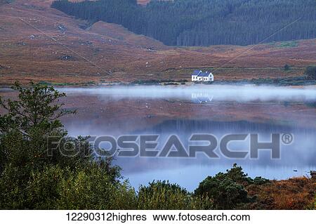 Stock Photograph - Lake reflections and mist; Dunlewey, County Donegal, Ireland. Fotosearch