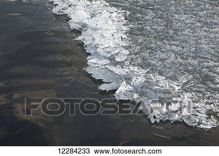 Stock Image - Lake water frozen and melted in springtime; Lake of the Woods, Ontario, Canada. Fotosearch