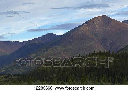 Stock Photograph - Late afternoon light shining on the mountains along the Wind River in the Peel Watershed; Yukon, Canada. Fotosearch