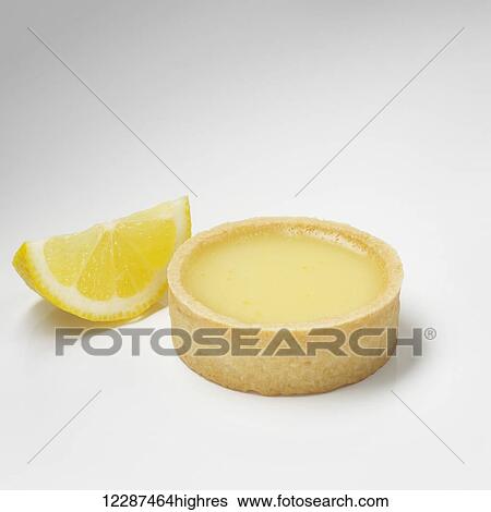 Stock Photograph - Lemon custard and a lemon wedge on a white background; Toronto, Ontario, Canada. Fotosearch