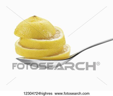 Stock Photograph - Lemon slices on a spoon on a white background; Toronto, Ontario, Canada. Fotosearch