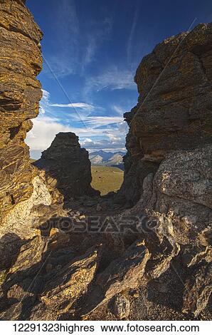 Stock Photograph - Light and shadows at Rock Cut formation near the Trail Ridge Road, with Long's Peak in the background, at Rocky Mountain National Park; Colorado, United States of America. Fotosearch