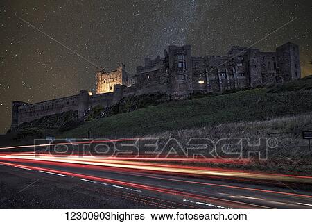 Light trails on a road and a star filled sky over Bamburgh Castle at nighttime; Bamburgh, Northumberland, England View Large Photo Image Stock Photograph - Light trails on a road and a star filled sky over Bamburgh Castle at nighttime; Bamburgh, Northumberland, England. Fotosearch