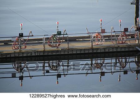 Lights and hoses on a pier are reflected in calm waters in the Sitka Harbor, Sitka, Southeast Alaska, USA, Summer View Large Photo Image Stock Photograph - Lights and hoses on a pier are reflected in calm waters in the Sitka Harbor, Sitka, Southeast Alaska, USA, Summer. Fotosearch