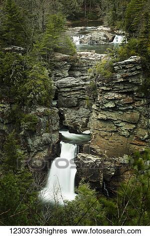 Stock Photograph - Long exposure of a cascading river with two small waterfalls in the background and one large waterfall in the foreground; North Carolina, United States of America. Fotosearch
