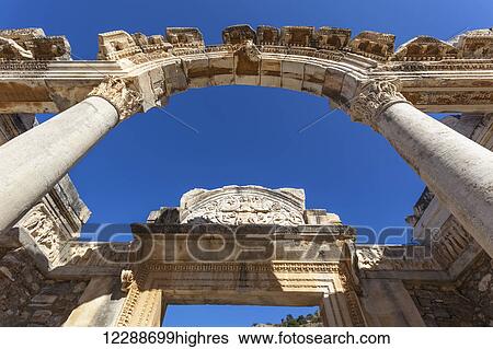 Stock Photograph - Low angle view of an arch in ancient ruins against a blue sky; Ephesus, Turkey. Fotosearch