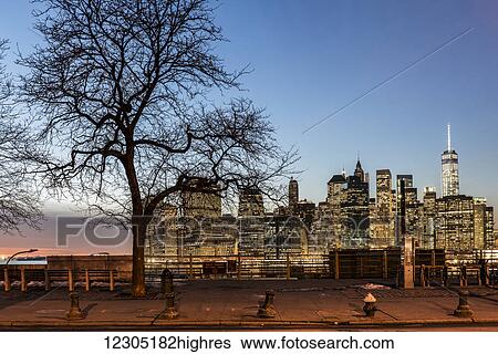 Stock Photograph - Lower Manhattan at twilight, Fruit Street sitting area; Brooklyn, New York, United States of America. Fotosearch