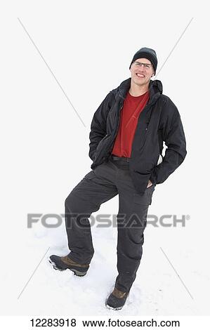 Stock Photo - Male dressed in winter gear and standing against a snowbank, Barrow, North Slope, Arctic Alaska, USA, winter. Fotosearch