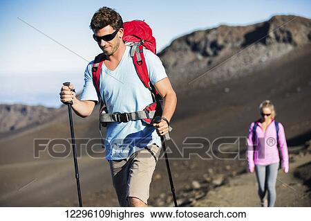 Man and woman hiking on beautiful mountain trail. Trekking and backpacking in the mountains. Healthy lifestyle outdoor adventure concept. View Large Photo Image Stock Photograph - Man and woman hiking on beautiful mountain trail. Trekking and backpacking in the mountains. Healthy lifestyle outdoor adventure concept.. Fotosearch
