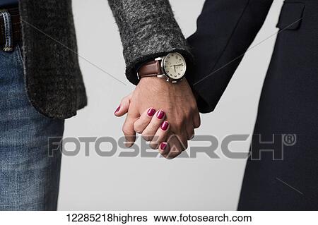 Stock Photograph - Man and woman holding hands, close up; Toronto, Ontario, Canada. Fotosearch