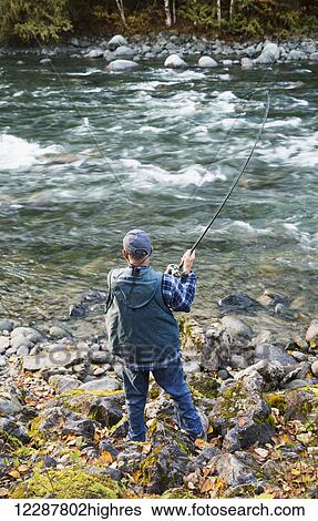 Stock Photograph - Man fishing in the Chilliwack River; Chilliwack, British Columbia, Canada. Fotosearch
