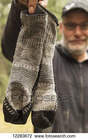 Man holding up his smelly socks after a two week canoe trip down the Wind River; Yukon, Canada View Large Photo Image Stock Image - Man holding up his smelly socks after a two week canoe trip down the Wind River; Yukon, Canada. Fotosearch