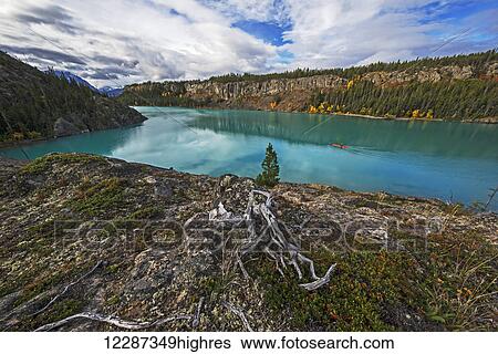 Stock Photograph - Man kayaking in Atlin Lake; British Columbia, Canada. Fotosearch