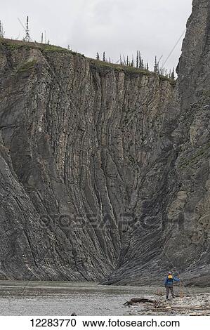 Man standing at the mouth of the Peel Canyon along the Peel River, part of the Peel Watershed; Yukon, Canada View Large Photo Image Stock Image - Man standing at the mouth of the Peel Canyon along the Peel River, part of the Peel Watershed; Yukon, Canada. Fotosearch