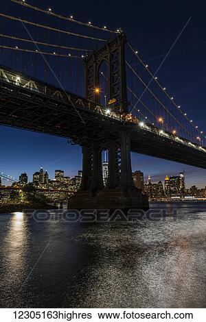 Stock Photograph - Manhattan Bridge and NYC skyline at twilight, Brooklyn Bridge Park; Brooklyn, New York, United States of America. Fotosearch