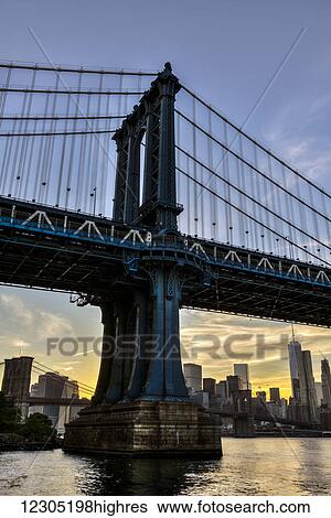 Stock Photograph - Manhattan Bridge and NYC skyline at sunset, Brooklyn Bridge Park; Brooklyn, New York, United States of America. Fotosearch