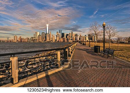 Stock Photograph - Manhattan skyline at sunset, Liberty State Park; Jersey City, New Jersey, United States of America. Fotosearch