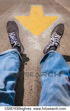 Man's legs and feet sitting near a yellow traffic arrow; Hartford, Connecticut, United States of America View Large Photo Image Stock Photograph - Man's legs and feet sitting near a yellow traffic arrow; Hartford, Connecticut, United States of America. Fotosearch