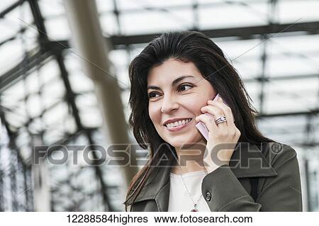 Mature business woman talking on her cell phone while taking a break in the atrium of an office building; Edmonton, Alberta, Canada View Large Photo Image Stock Photograph - Mature business woman talking on her cell phone while taking a break in the atrium of an office building; Edmonton, Alberta, Canada. Fotosearch