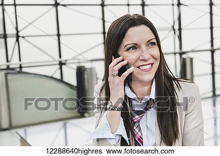 Mature business woman talking on her cell phone in the atrium of an office building; Edmonton, Alberta, Canada View Large Photo Image Stock Photograph - Mature business woman talking on her cell phone in the atrium of an office building; Edmonton, Alberta, Canada. Fotosearch