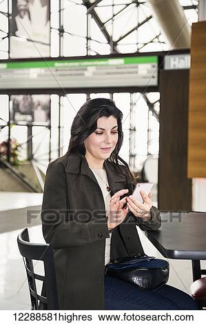 Mature business woman texting while taking a break in the atrium of an office building; Edmonton, Alberta, Canada View Large Photo Image Stock Photograph - Mature business woman texting while taking a break in the atrium of an office building; Edmonton, Alberta, Canada. Fotosearch