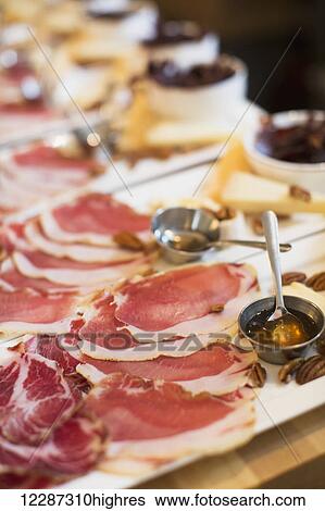 Stock Photograph - Meat, honey, cheese, and pecan trays; Toronto, Ontario, Canada. Fotosearch