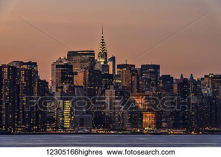 Stock Photograph - Midtown Manhattan skyline at sunset; New York City, New York, United States of America. Fotosearch