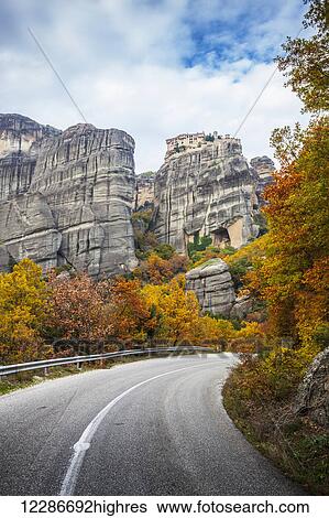 Monastery perched on a cliff, a road and autumn foliage; Meteora, Greece View Large Photo Image Stock Photograph - Monastery perched on a cliff, a road and autumn foliage; Meteora, Greece. Fotosearch