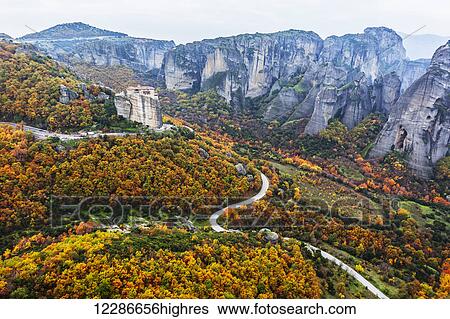 Stock Photograph - Monastery perched on a cliff with autumn coloured foliage; Meteora, Greece. Fotosearch