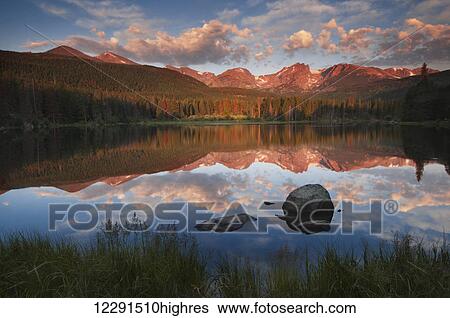 Stock Photograph - Morning light reflects on a calm Sprague Lake in Rocky Mountain National Park; Colorado, United States of America. Fotosearch