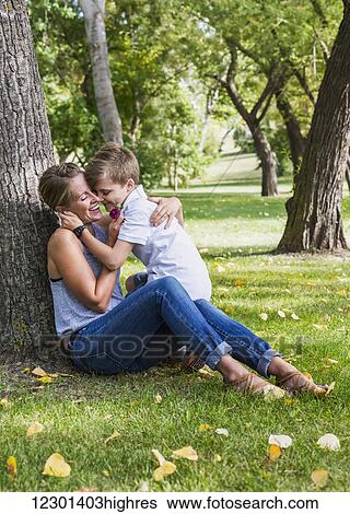 Mother getting a flower from her son while spending quality time at a park during a family outing; Edmonton, Alberta, Canada View Large Photo Image Stock Photograph - Mother getting a flower from her son while spending quality time at a park during a family outing; Edmonton, Alberta, Canada. Fotosearch