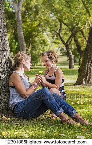 Mother getting a flower from her daughter while spending quality family time at a park; Edmonton, Alberta, Canada View Large Photo Image Stock Photograph - Mother getting a flower from her daughter while spending quality family time at a park; Edmonton, Alberta, Canada. Fotosearch